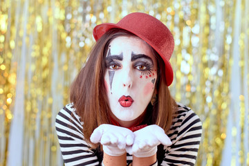 girl dressed in mime with red hat, red bow tie, striped shirt and white gloves.