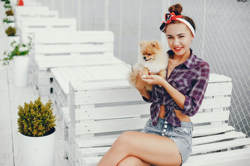 Elegant pin up lady in a shirt in a cell. Girl sitting with cute little dog