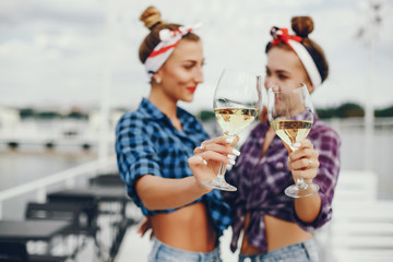 Elegant pin up ladies in a shirt in a cell. Girls with glass of vine