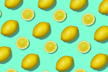 Colorful fruit pattern of fresh lemon and lemon slices on aqua mint background. Lemon slices top view, flat lay