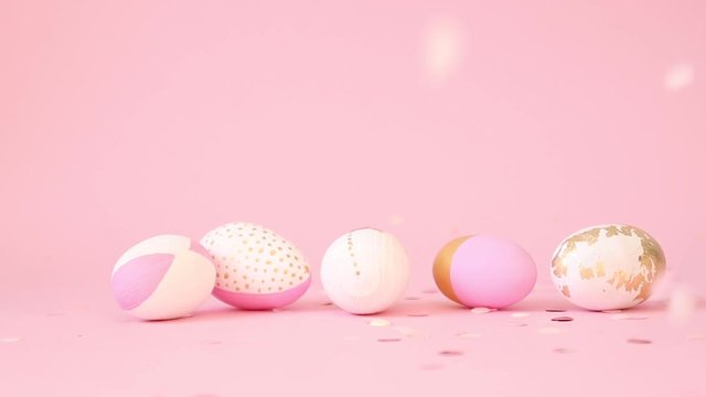 Gently pink and golden eggs spin on a pink background, slow motion. Happy Easter. Golden shine decorated eggs, golden splash conffety for ad, promotion, web