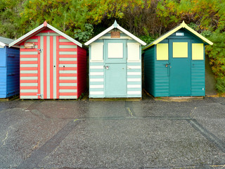 Fototapeta na wymiar Three stripe beach huts in primary colours on Lowestoft sea front.