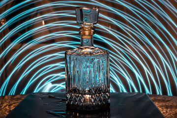 Faceted glass decanter with alcohol. Abstraction on the topic of alcoholism.