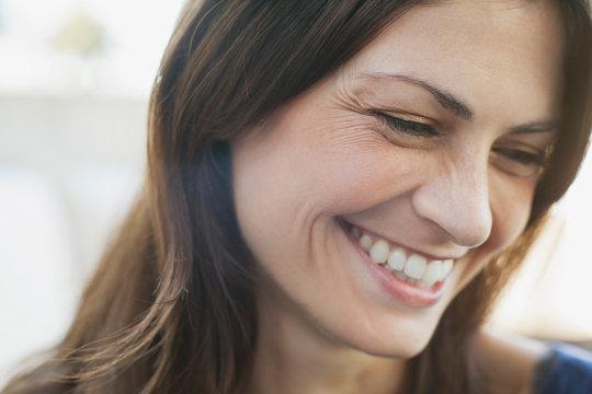 Mid adult woman laughing and looking down