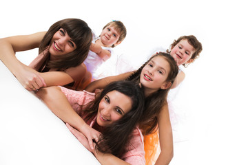 Happy girls and children posing together lying in funny pose, white background in the photo