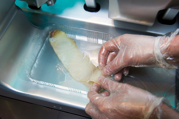 Chef cutting fish, on a slicer