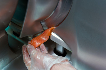 Chef cutting fish, on a slicer