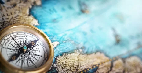 Fotobehang Magnetisch kompas op wereldkaart. Reizen, aardrijkskunde, navigatie, toerisme en exploratie concept achtergrond. Macrofoto. Zeer oppervlakkige focus. © Tryfonov