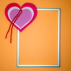 St. Valentine's Day. Heart symbol in silver frame on a salmon-coloured background.