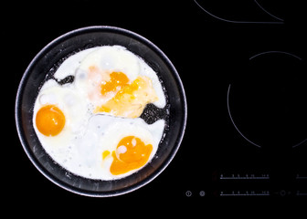 Tree fried eggs cooked in frying pan