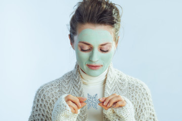 modern female with green facial mask holding snowflake