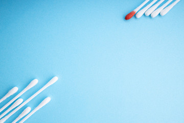 Blood on the hygiene cotton stick. Skincare mockup for design. Menstruation. Stack of disposable cotton stick on a blue background. Cosmetology concept. Bloody wound. Injury. ..