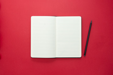 Open notebook isolated on red background, copy space for text.