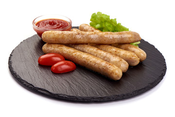 Grilled Chicken Sausages with tomato sauce and salad leaves, on a stone plate, isolated on white background