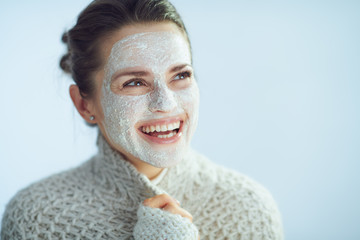 happy modern woman with white facial mask looking at copy space