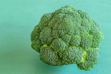 Fresh big broccoli on the green background. Healthy vegetable diet food concept.