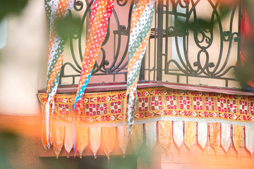 Abstract background. An old balcony decorated with multicolored fabrics with patterns.