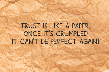 Fototapeta na wymiar Trust Is Like A Paper Once Its Crumpled quote over Crumpled Brown Paper Background