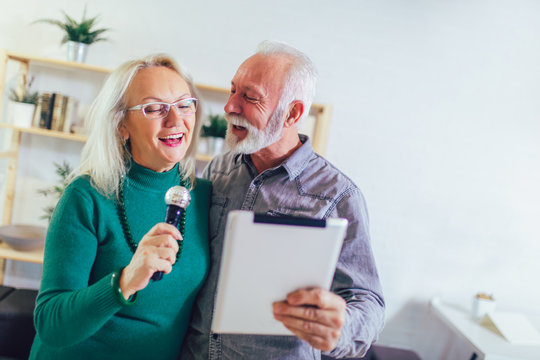 Senior Couple Singing Karaoke At Home, Having Fun.