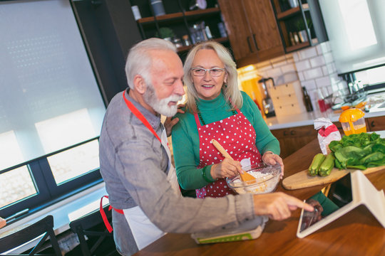 Senior Couple Preparing Food In The Kitchen.