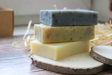 Handmade natural soap on wooden background. Spa natural treatments.Natural soap, handmade organic natural soap with body brush, oil bottle and cotton towel, spa and wellness products.