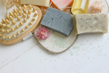Handmade natural soap on wooden background. Spa natural treatments.Natural soap, handmade organic natural soap with body brush, oil bottle and cotton towel, spa and wellness products.