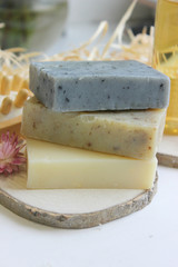 Handmade natural soap on wooden background. Spa natural treatments.Natural soap, handmade organic natural soap with body brush, oil bottle and cotton towel, spa and wellness products.