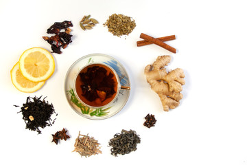  Filiżanka z herbatą otoczona różnymi gatunkami herbat oraz rozgrzewającymi leczniczymi przyprawami i dodatkami do herbaty - obrazy, fototapety, plakaty