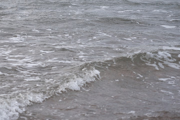  Blurred waving surface of stormy sea water on a sunset with reflection of the sunlight as a natural background.