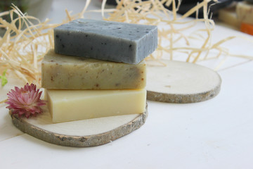 Handmade natural soap on wooden background. Spa natural treatments.Natural soap, handmade organic natural soap with body brush, oil bottle and cotton towel, spa and wellness products.