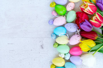 Fototapeta na wymiar Easter colored eggs with tulips
