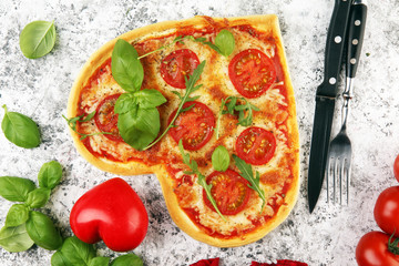 pizza Heart shaped margherita with tomatoes and mozzarella vegetarian. Food concept of romantic love pizza for Valentines Day.