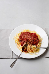 Homemade Spaghetti with Meat Sauce in White Plate on Neutral Gray Background