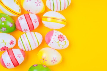 Fototapeta na wymiar Colorful easter painted eggs background on yellow pastel color background with space. Easter holiday concept. Traditional decoration for springtime holiday. Top view easter greeting card