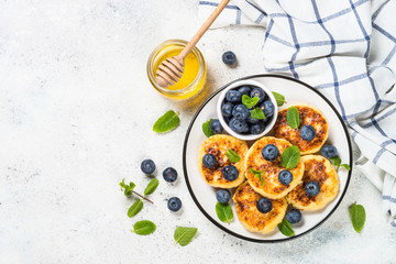 Cottage cheese pancakes on white table.