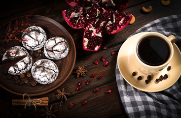 coffee with gingerbread cookies and pomegranate on a wooden background