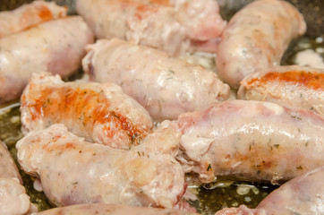 Sausages for grilling fried in a pan close-up