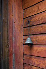 a metal bell on an old wooden wall