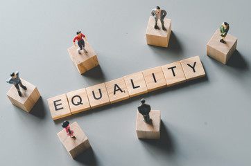 gender equality, miniature men and women stand around 