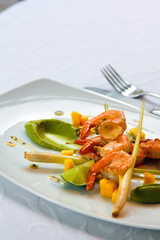 fried shrimps with vegetables and sauce on a white plate