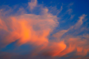 Beautiful red, pink feather clouds against the dark sky in sunrise, sunset. Scenic fantastic clouds. Landscape background