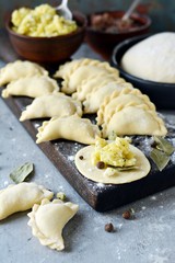 Dumplings with potatoes with herbs on a blue background. Varenyky, vareniki, pierogi, pyrohy - dumplings with filling.