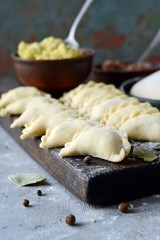 Dumplings with potatoes with herbs on a blue background. Varenyky, vareniki, pierogi, pyrohy - dumplings with filling.