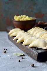 Dumplings with potatoes with herbs on a blue background. Varenyky, vareniki, pierogi, pyrohy - dumplings with filling.