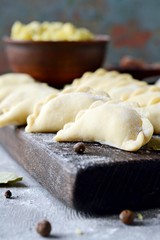 Dumplings with potatoes with herbs on a blue background. Varenyky, vareniki, pierogi, pyrohy - dumplings with filling.