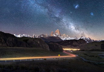 Beautiful light trails towards remote town El Chalten - Fitz Roy Mountain visible under Milky Way