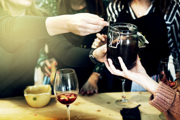 Woman and man teach her friends how to cook food - piza or pie. People cooking at kitchen together....