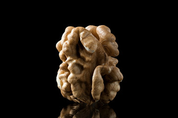 Macro photo of kernel walnut with reflection on a black background with clipping path and reflection.