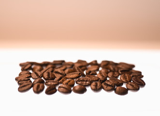 Frische braun geröstete Kaffebohnen (Koffein) in Detailaufnahme auf weiß, hell erleuchtetem Hintergrund freigestellt; Makro von Bohnen für Zubereitung von koffeinhaltigem Heißgetränk