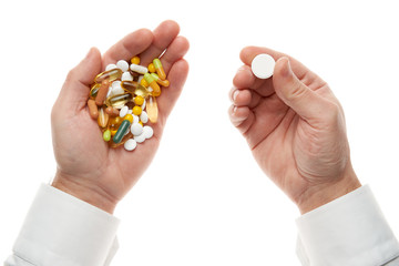 Man hand getting one pill from handful of pills, tablets, vitamins, drugs, capsules isolated on white background. White shirt, business style. Health care concept. Pharmaceutical industry. Pharmacy.